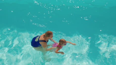 mother teaching daughter to swim