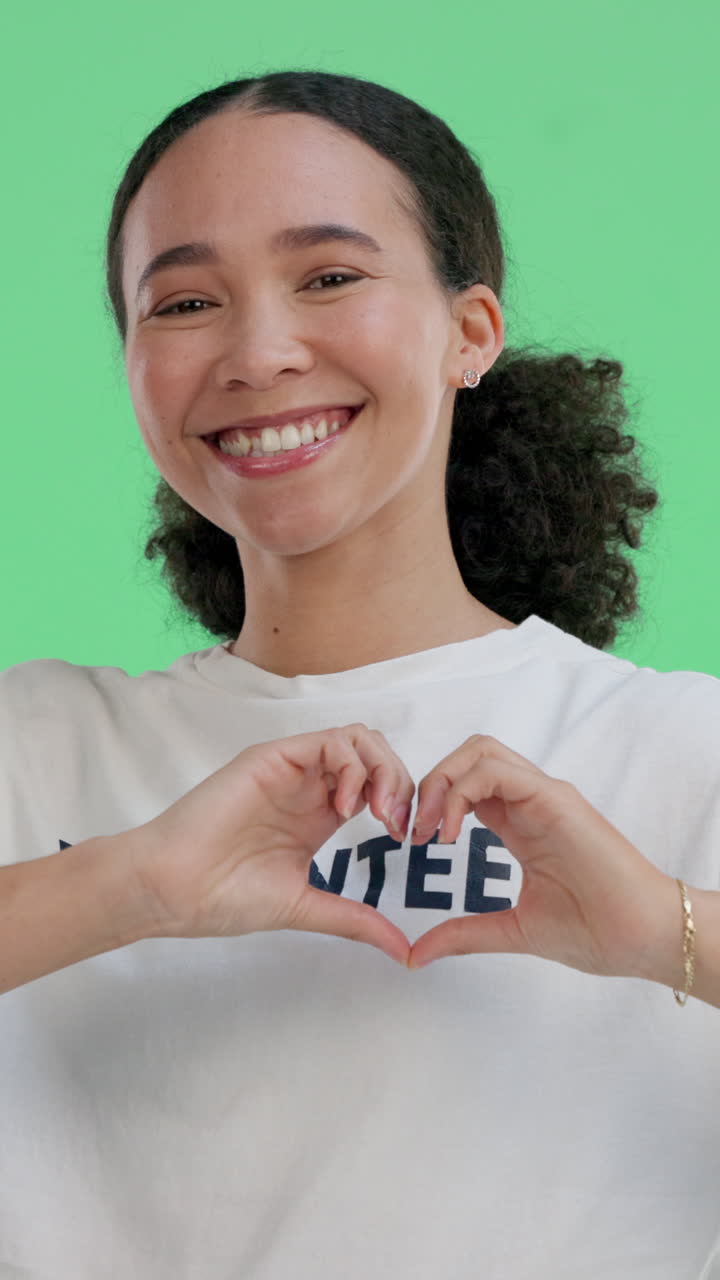 Mujer joven feliz haciendo un gesto de corazón en pantalla verde