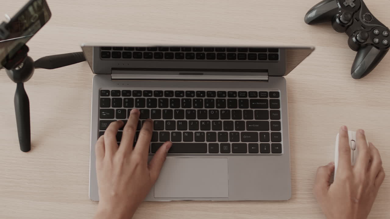 Hands of Gamer Using Laptop Keyboard
