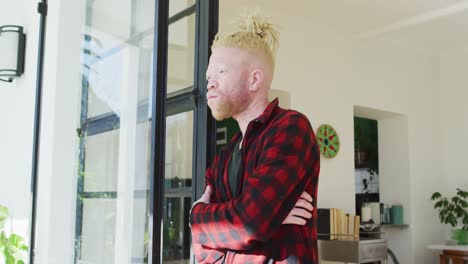 Thoughtful-albino-african-american-man-with-dreadlocks-looking-at-the-window