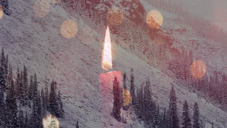 composite video of burning candle and spots of light against landscape with snowy mountains