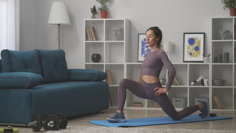 stretching workout at home young woman is training alone in living room sitting on sport mat in modern apartment healthy lifestyle