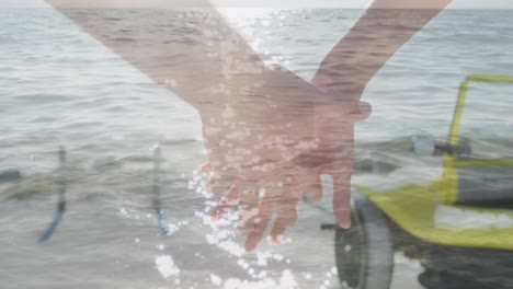 animación de la luz sobre las manos de una pareja caucásica caminando por la playa