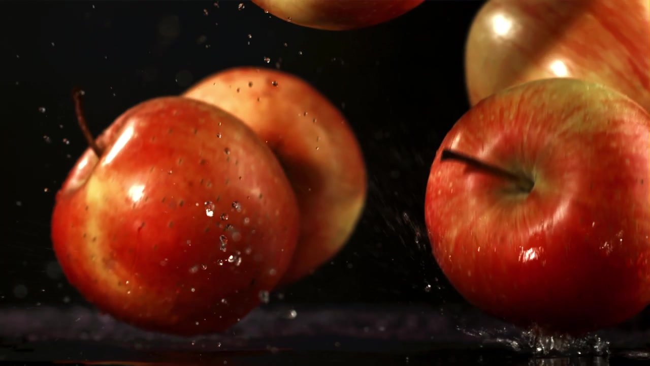 Fresh Red Apples Splashing into Water on Black Background