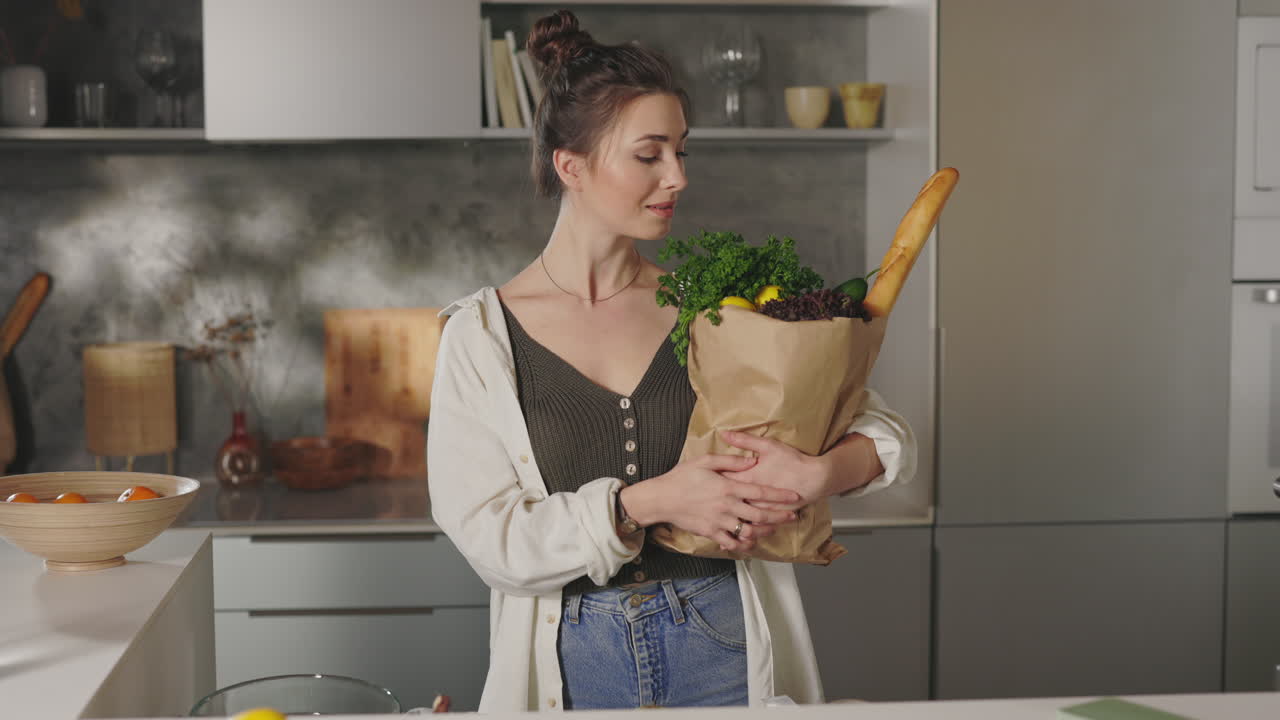 Woman holding a bag of groceries in a kitchen