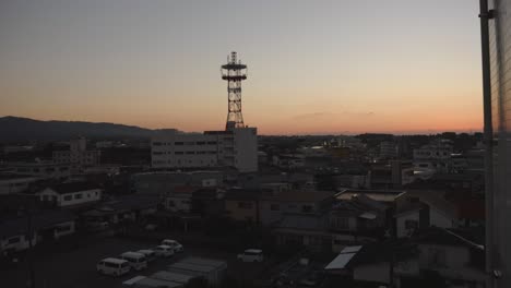 dusk settles over izumi, japan with a silhouette of a communication tower, urban landscape bathed in twilight