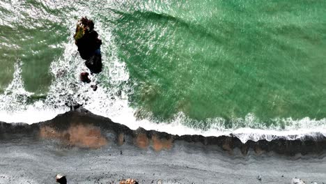 ireland epic drone looking down on dramatic colours of emerald sea multi coloured shingle beach copper coast waterford ireland summer morning