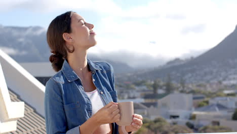 young woman enjoying morning coffee on balcony, embracing peaceful mountain view, copy space
