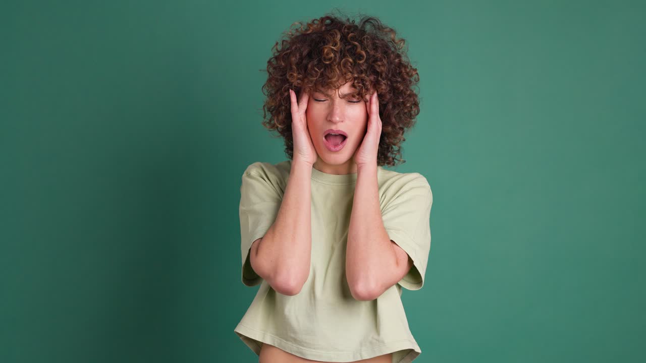 Adult woman with her hands on her head because of a headache