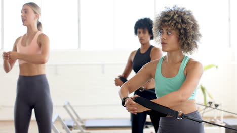 three women are training in bright yoga pilates studio