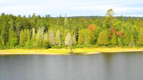 Imágenes-Aéreas-De-Principios-De-Otoño-De-Un-Lago-Remoto-En-El-Norte-De-Maine-Volando-Hacia-La-Costa-Dolly-Zoom