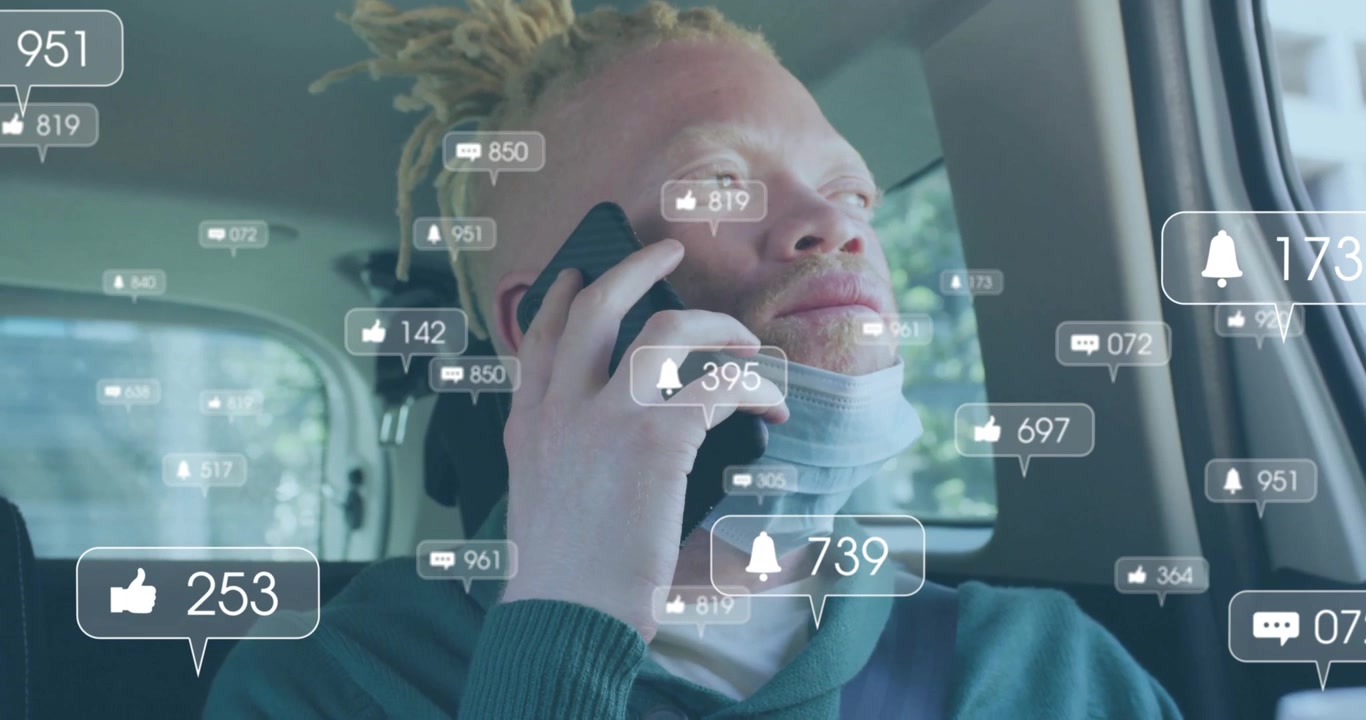 Uomo che sorseggia da una tazza e parla al telefono in auto, attivando avvisi AR che tracciano le metriche sociali.