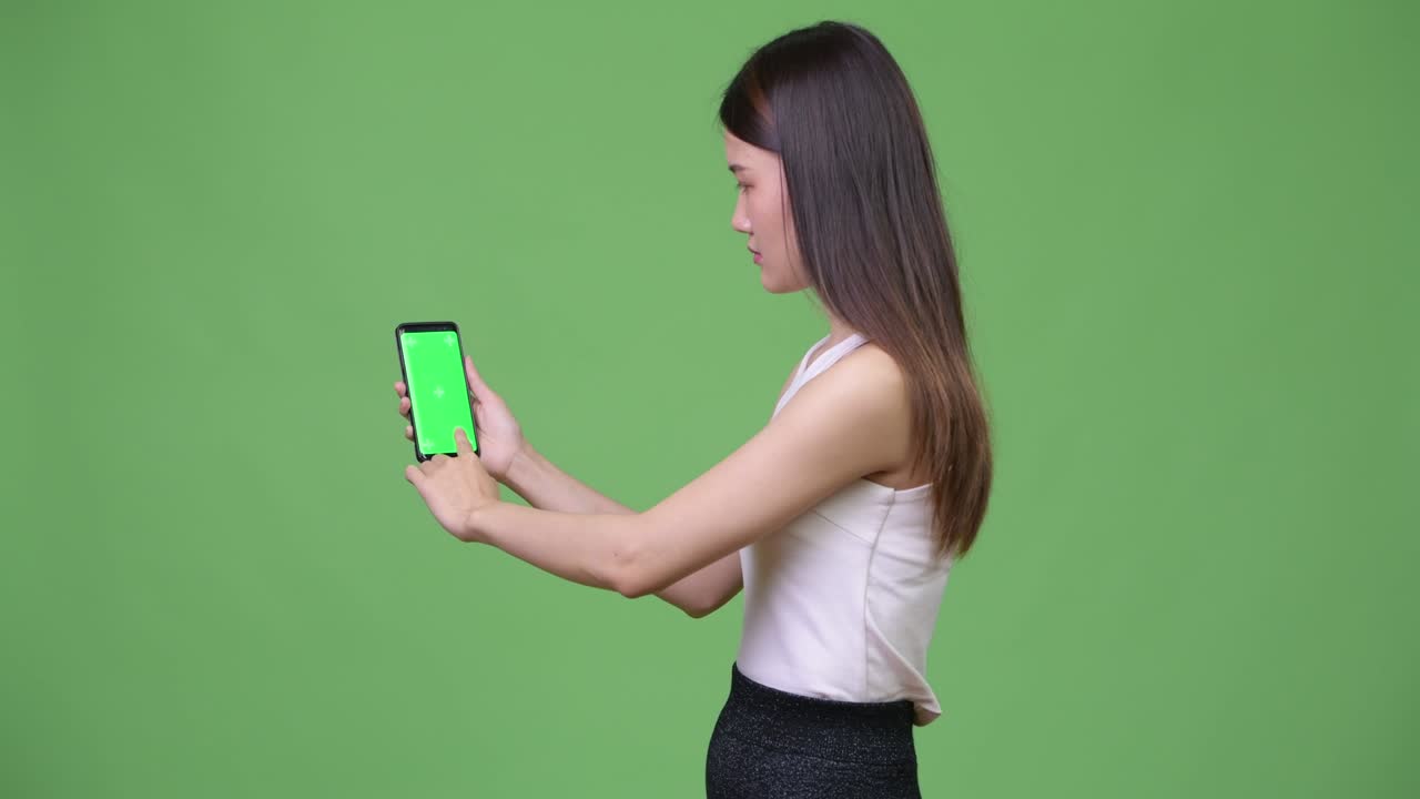 젊은 아름다운 아시아 사업가 여성이 전화를 보여주고 있습니다.