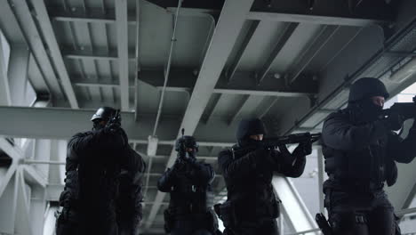 Police-special-forces-protecting-building.-SWAT-officers-in-masks-using-rifles