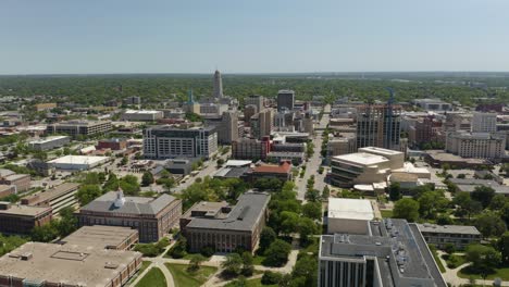 aerial establishing shot of downtown lincoln, nebraska with state capitol building in background