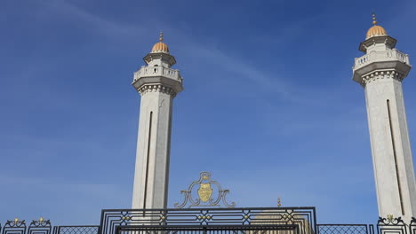 towers of a tunisian mausoleum rise against a clear blue sky, showcasing intricate architecture