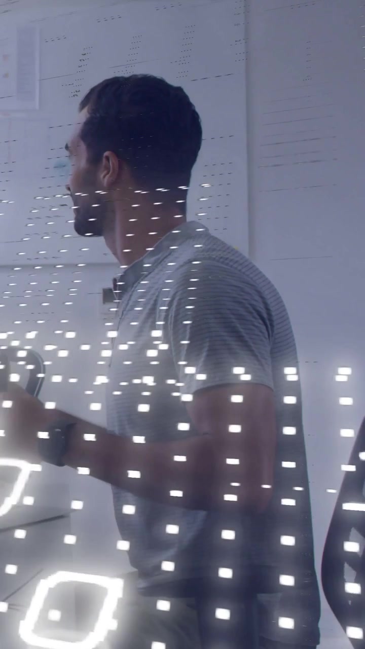 Vertical video: Man tapping controller at desk, activating projected numeric grid for tech review