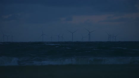 wind turbines producing sustainable renewable energy in an offshore wind park during dusk.
