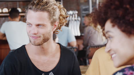 Group-Of-Friends-Meeting-For-Meal-In-Restaurant-Sitting-Around-Table-Talking