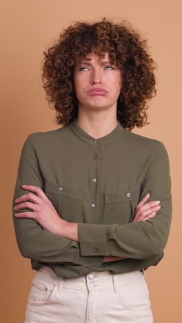 disagreeing young woman shaking head with twisted mouth on beige background. vertical orientation