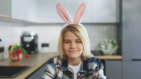 child with easter bunny ears in kitchen