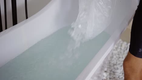 Man-filling-bath-with-ice-cubes