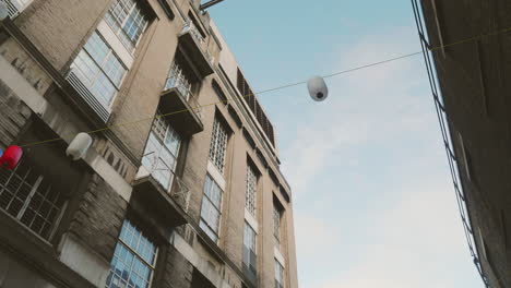 Chinesische-Lampen,-Die-Im-Wind-Zwischen-Häusern-In-Chinatown,-London,-Baumeln