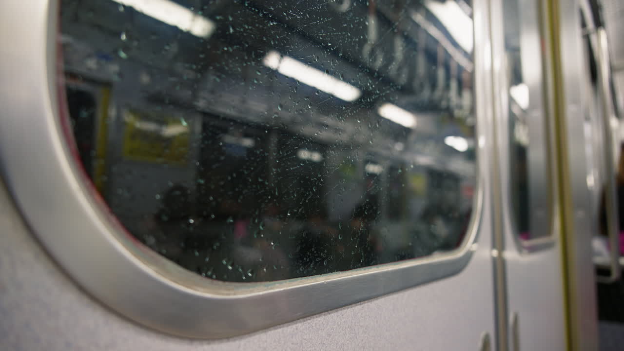 Blurred view from a train window of a train passing by on a rainy evening