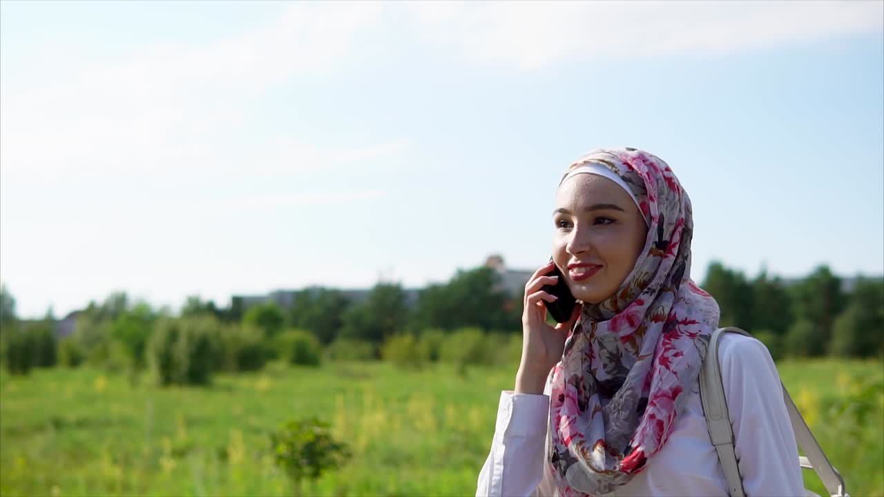 Young Woman in Hijab Talking on Phone Outdoors