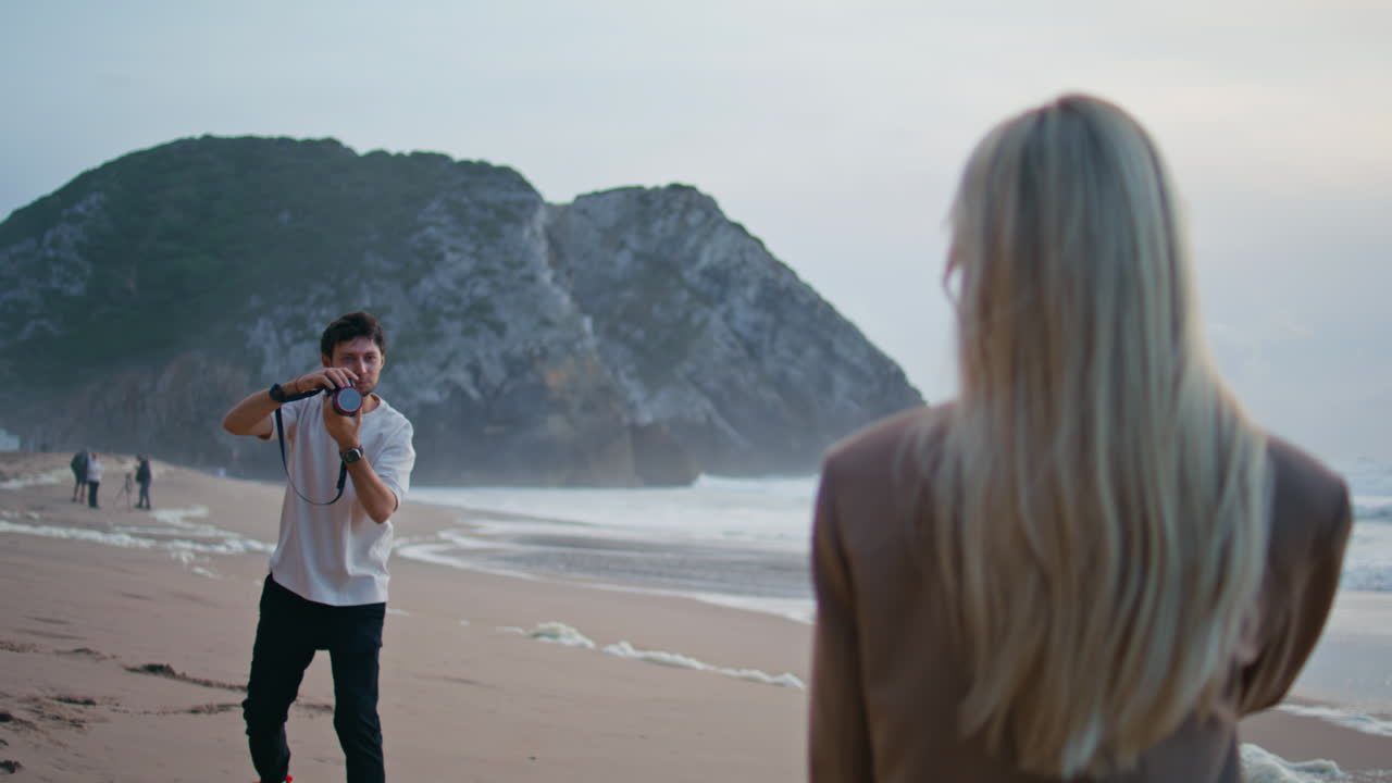 바가에서 사진을 찍는 패션 사진작가. 금발 모델이 뒤에서 포즈를 취하고 있다.