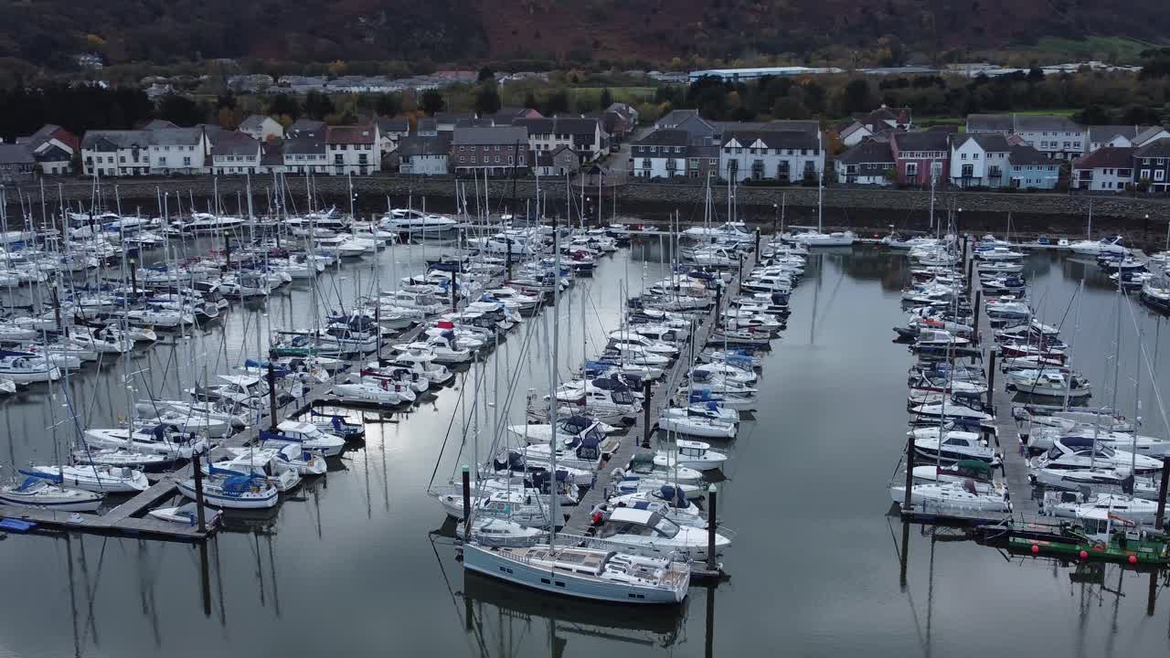 pintoresco puerto de lujo frente al mar apartamento pueblo yates y veleros bajo vista aérea de la costa de montaña órbita izquierda