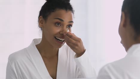 una mujer afroamericana atractiva usando parches en los ojos.