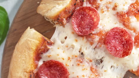 desgarrando una rebanada de pizza de pepperoni en cámara lenta, vista de la mesa del queso mozzarella elástico