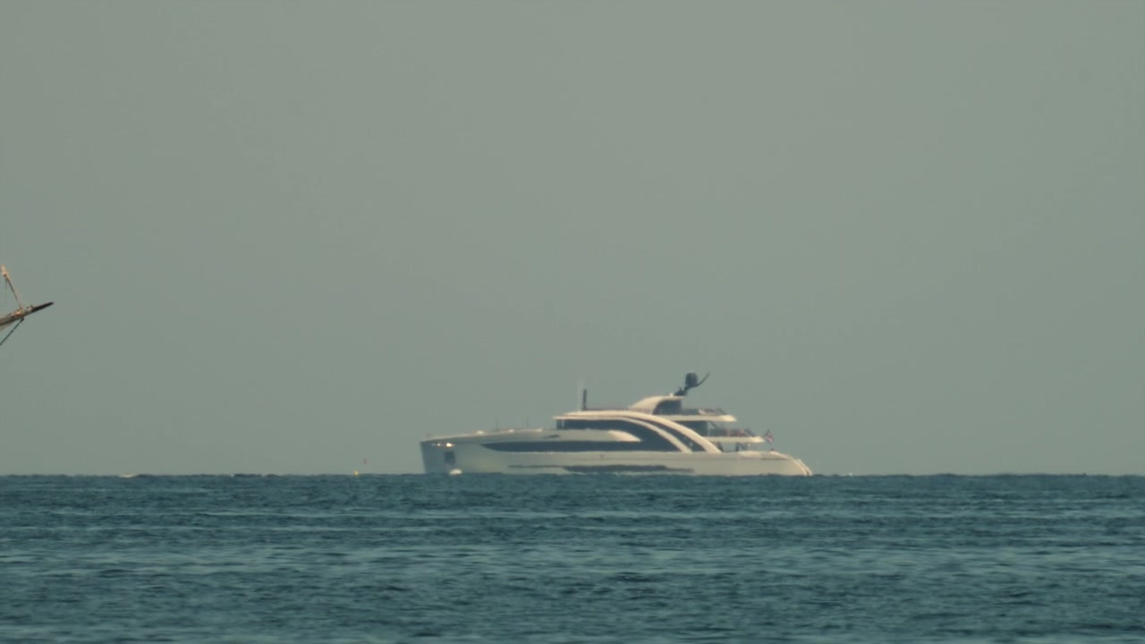 Superyacht Venus, progettato per Steve Jobs, che naviga l'orizzonte calmo dell'oceano, mostrando linee eleganti e minimaliste e viaggi di lusso.