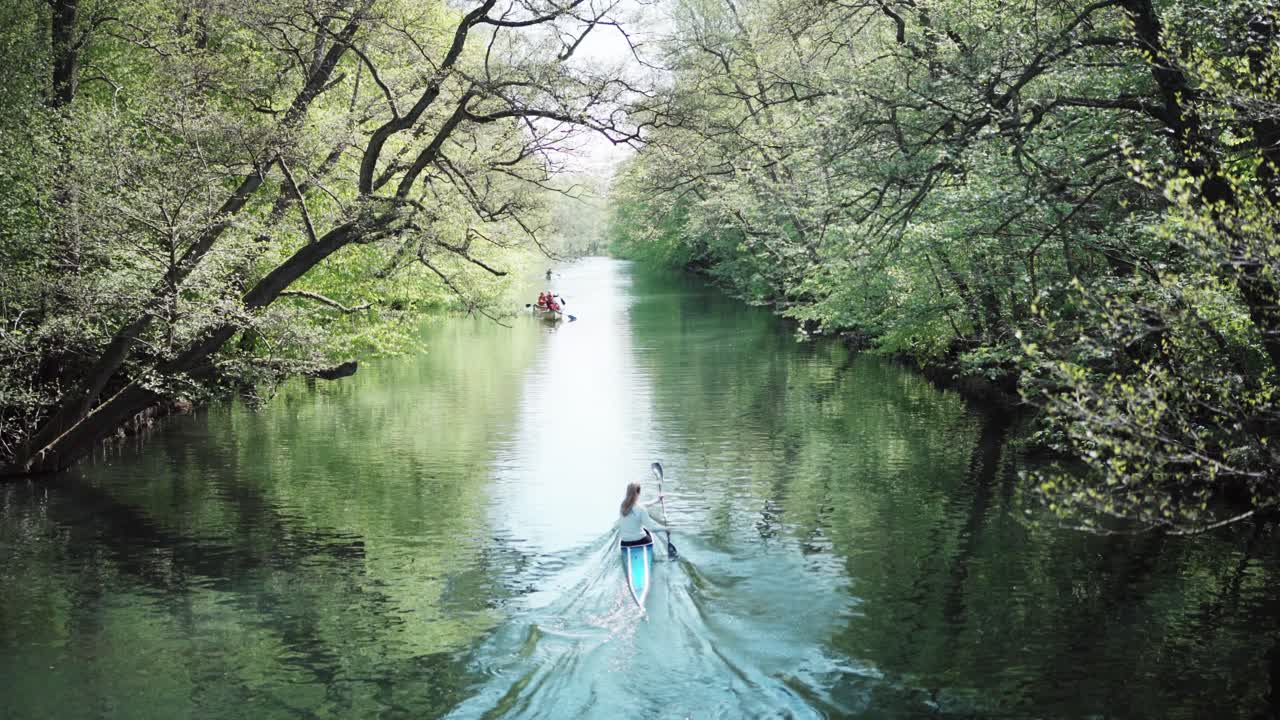 Fit nordic girl paddling down river in sunny copenhagen