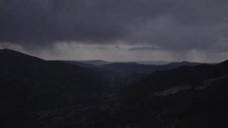 this drone video captures a stunning frontal descriptive shot over the hecho valley in the aragonese pyrenees, spain, with snowy mountains in the background under a cloudy sunset.