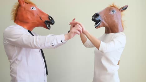 family couple in latex horse mask dancing funny at home family couple in latex horse mask dancing funny at home