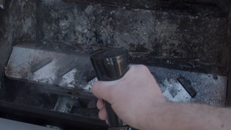 hand spraying cleaner on dirty barbecue in slow motion