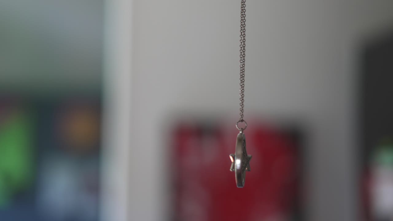 g 기호가 매달려 있고 배경에 다채로운 예술 작품이 있는 회전하는 프리메이슨 프리 메이슨 부적 목걸이