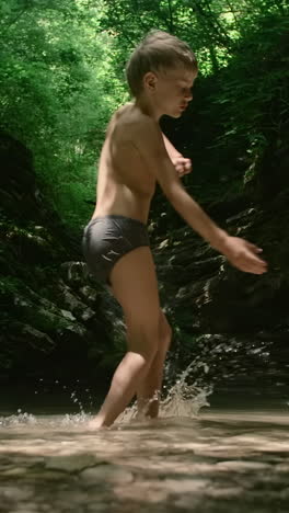 boy playing in a forest creek