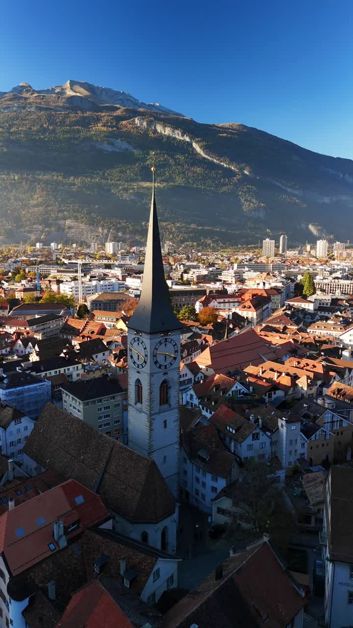 Spire and clock tower of the St. Martin's Church in Chur, Switzerland aerial drone