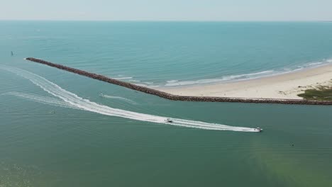 toma aérea de lanchas rápidas que navegan hacia la desembocadura del río provenientes del océano azul