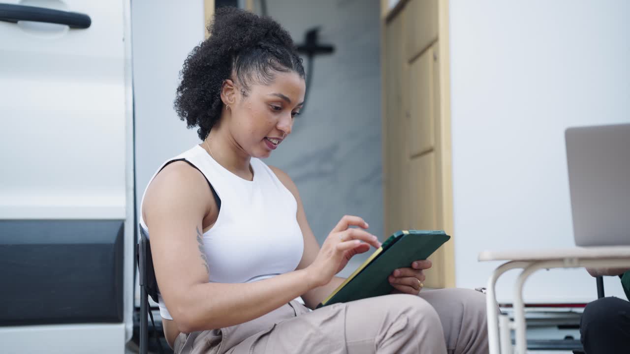 Woman using tablet outdoors by RV