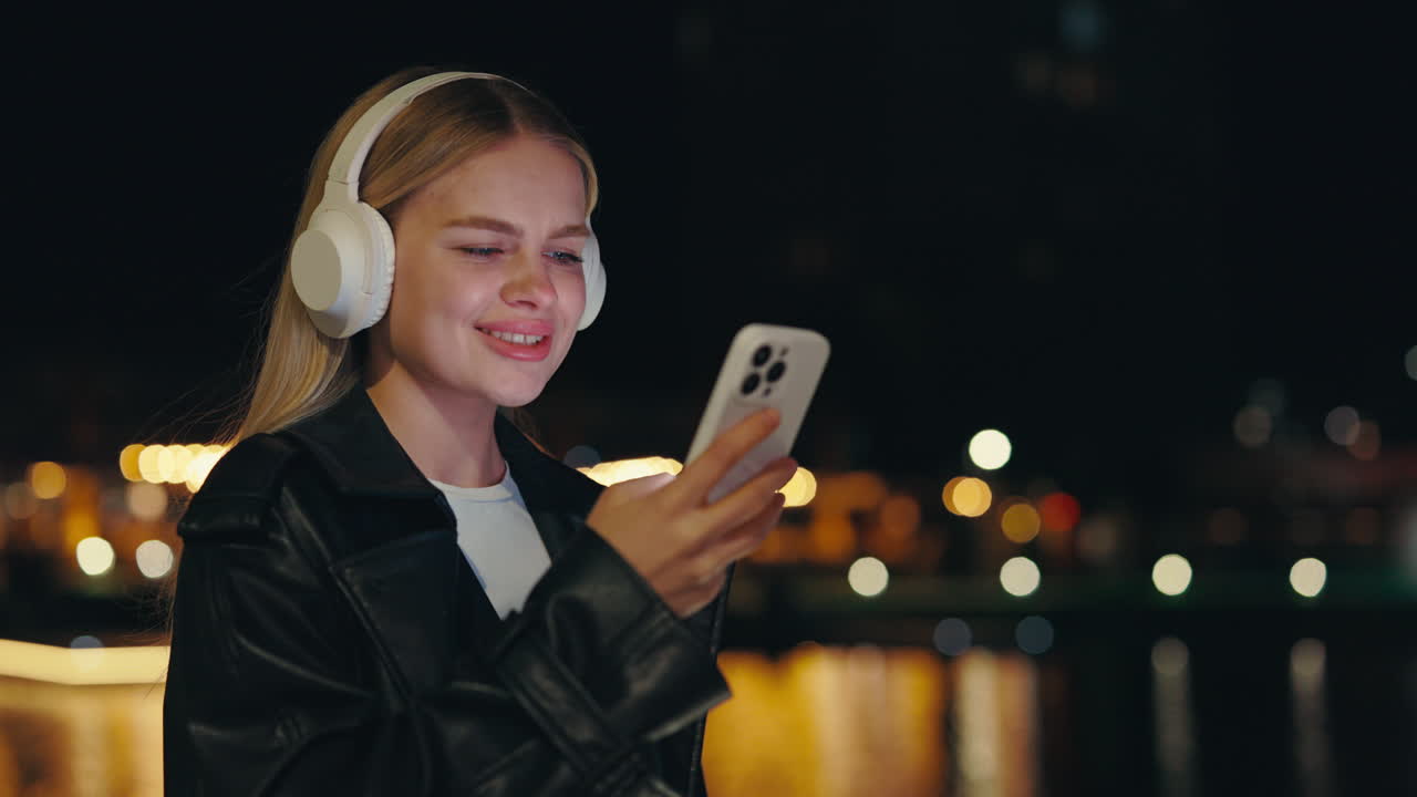 Donna che usa il telefono con le cuffie di notte