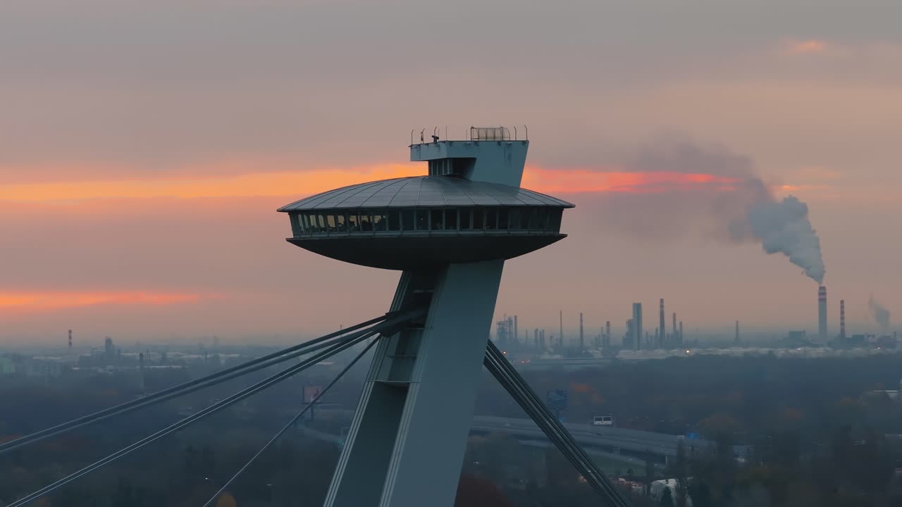 4K cinematic drone footage of the UFO Tower in Bratislava, showing the futuristic observation deck rising above the SNP Bridge with sweeping views of the Danube River _16