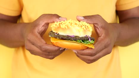 un primer plano de una hamburguesa en las manos de alguien.