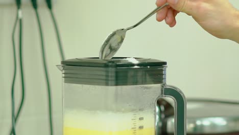 cook adds flour to the mixer with whipped eggs