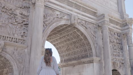 junge touristin blickt auf den titusbogen in rom, italien