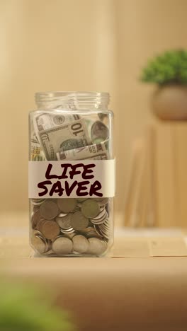 vertical video of person saving money for life saver