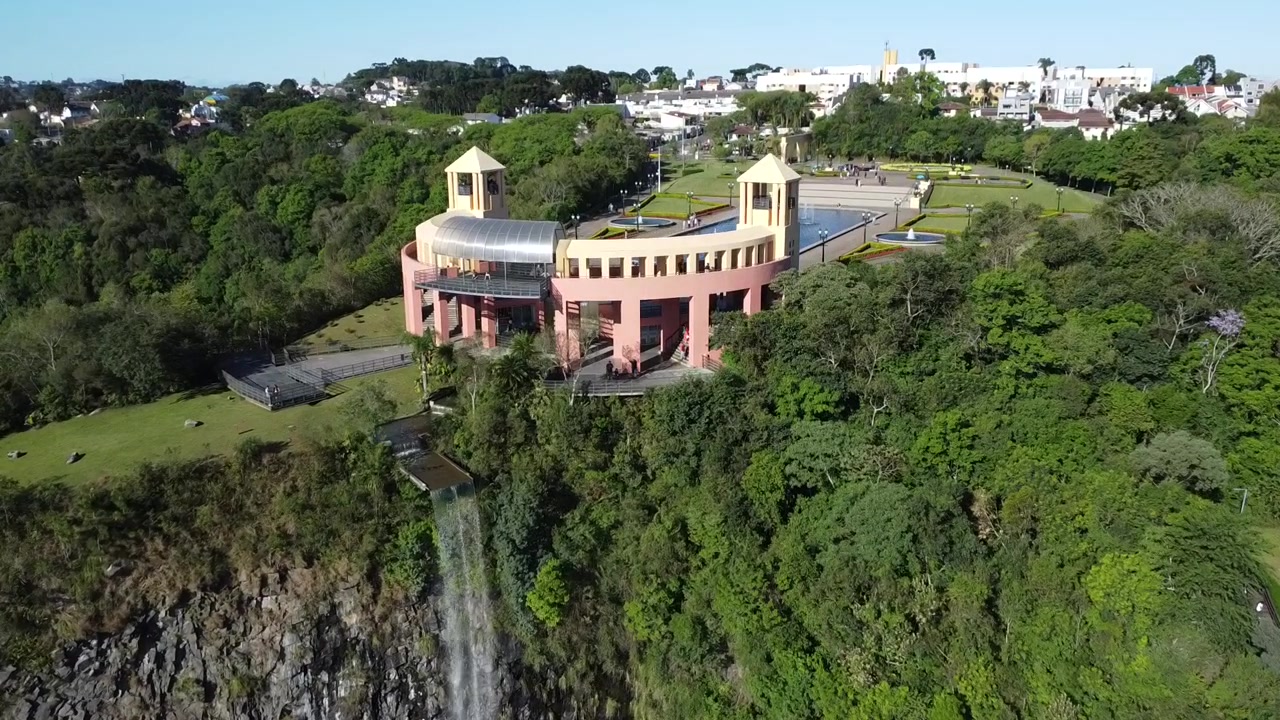 Rekaman drone yang naik di dekat air terjun indah yang dikelilingi bebatuan dan alam subur di kota Curitiba, Brasil.